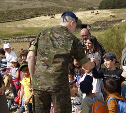 Su Majestad el Rey saluda a uno de los alumnos de los colegios de la zona que estuvieron presentes a su llegada al Refugio "El Mellizo", en 