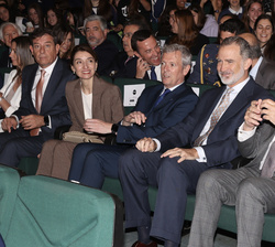 Su Majestad el Rey en el patio de butacas con las autoridades y personalidades asistentes al acto rodeado de jóvenes participantes en la cuarta etapa 