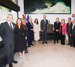 Su Majestad el Rey junto a una placa inaugural del edificio y las autoridades que le recibieron a su llegada