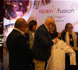 Momento en el que hacen entrega a Doña Sofía de una chaquetilla de chef durante su recorrido por la Spain Fusion Texas 2023