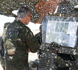 Su Majestad el Rey observa un mapa del terreno en un puesto de comunicaciones en el Aeródromo Militar de Ablitas