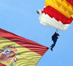 Momentos antes de hacer tierra la cabo del Ejército de Aire, Carmen Gómez Hurtado, primera mujer en realizar el salto en paracaidista portando la band