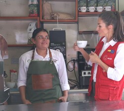 Su Majestad la Reina prueba uno de los cafés de la zona