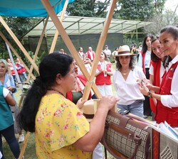 Doña Letizia conversa con una mujer durante su recorrido por los stands  de los distintos proyectos de la cooperación española en la región