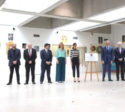 Su Majestad la Reina junto a una placa conmemorativa del acto
