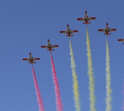 Vista del desfile de la Patrulla Acrobática "Águila" que despliega la Bandera de España tras el acto a los caidos