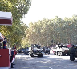 Sus Majestades los Reyes y Su Alteza Real la Princesa de Asturias al paso de una de las unidades motorizadas que participan en el desfile