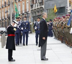 Su Majestad el Rey frente a la Enseña Nacional al pasar revista a las tropas