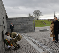 Los Reyes y los Principes Herederos mientras un soldado danes coloca la ofrenda de flores de Sus Majestades los Reyes