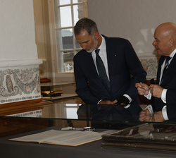 Su Majestad el Rey con el presidente del Parlamento de Dinamarca observan unas Constituciones danesas