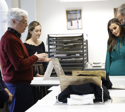 Sus Majetades los Reyes y la Reina de Dinamarca observan unos libros en el taller de restauración de textos del departamento de lenguas de la Universi