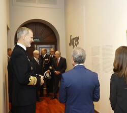 Su Majestad el Rey conversa con las personas que le acompañan durante el recorrido por el Museo