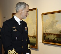 Su Majestad el Rey observa una de las obras de la exposición