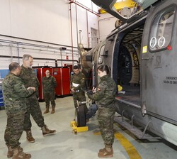 Don Felipe recibe explicaciones de uno de los helicópteros durante su recorrido por el hangar de mantenimiento