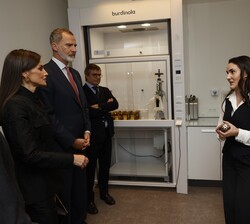Sus Majestades los Reyes atienden a las explicaciones a su paso por uno de los laboratorios de la compañía Puig