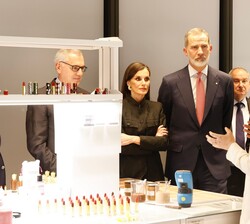 Sus Majestades los Reyes atienden a las explicaciones recibidas durante su recorrido por las instalaciones de la compañía Puig