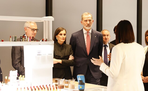 Sus Majestades los Reyes atienden a las explicaciones recibidas durante su recorrido por las instalaciones de la compañía Puig