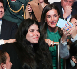 Su Majestad la Reina se fotografía con dos jóvenes, durante el acto de proclamación del Premio “Arte 2024”, de la Fundación Princesa de Gi