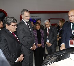 Don Felipe atiende a las explaciones durante su visita al pabellón de Vodafone