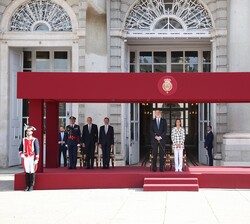 Sus Majestades los Reyes en la tribuna de honor durante la interpretación del Himno Nacional