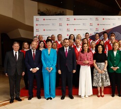 Su Majestad la Reina con voluntarios de la Cruz Roja Española y las autoridades asistentes al acto