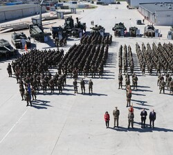 Fotografía de grupo con el contingente español en la explanada Motorpool