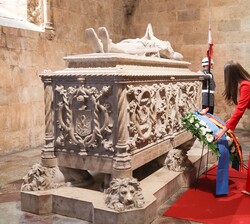 Doña Leonor arregla la cinta de la tumba de Luis de Camões