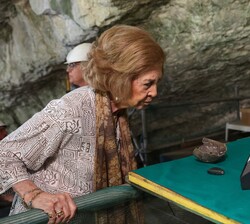 La Reina Sofía observa algunos elementos hallados en la Cueva Mayor