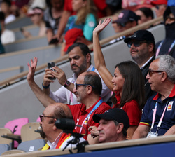 La Reina saluda desde su lugar de asiente antes del comienzo del partido de tenis de Carlos Alcaraz