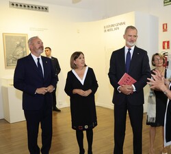 Su Majestad el Rey atiende a las explicaciones durante su visita a la exposición