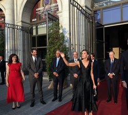 Don Felipe y Doña Letizia junto a las autoridades que les recibieron a su llegada saludan al público que se encuentra en la puerta del Teatro Real