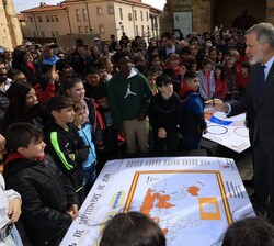Don Felipe junto a un grupo de alumnos que le explican el mural que, sobre países de habla hispana, han elaborado