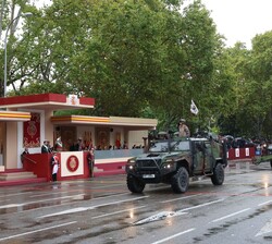 Sus Majestades los Reyes y Su Alteza Real la Princesa de Asturias al paso de una de las unidades motorizadas que participan en el desfile