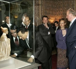 Don Juan Carlos junto a la secretaria de Estado de Cooperación Internacional y el alcalde de Sevilla, observan una de las piezas de la exposición