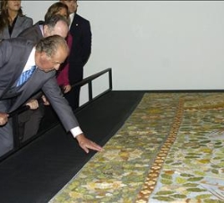 Su Majestad observa uno de los tapices de la exposición