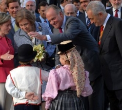 Sus Majestades saludan a unos niños que les recibieron a su llegada al Espacio Multifuncional El Polvorín, en el barrio de Taco