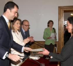 Don Felipe entrega su diploma a una alumna, en presencia de Doña Letizia