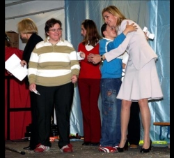 Doña Cristina con unos jóvenes en el escenario, durante la entrega de juguetes