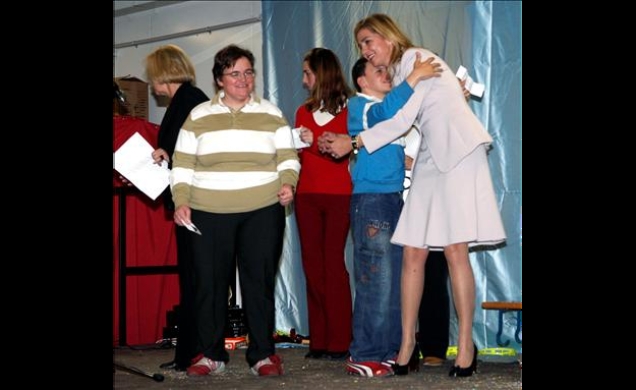 Doña Cristina con unos jóvenes en el escenario, durante la entrega de juguetes