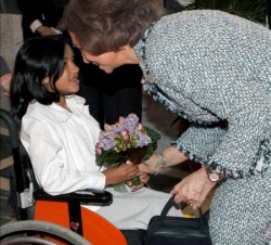 Su Majestad la Reina, a su llegada, recibe unas flores de manos de una niña