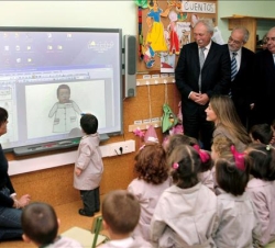 Doña Letizia junto a las autoridades invitadas al acto, conversa con un grupo de niños del colegio asturiano