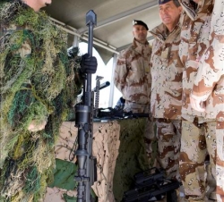 Su Majestad junto a un tirador, equipado con un fusil Barrett M82