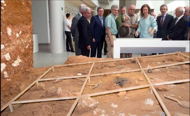 Su Majestad la Reina atiende las explicaciones del co-director de los yacimientos de Atapuerca, Eudald Carbonell