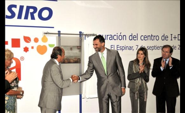 Don Felipe recibe el saludo del presidente del Grupo Siro tras descubrir una placa conmemorativa