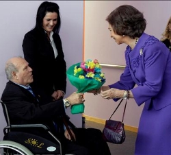 La Reina recibe de manos de uno de los usuarios del Centro, un ramo de flores
