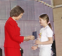 Una de las niñas participantes en el concurso recibe el premio de manos de Doña Sofía