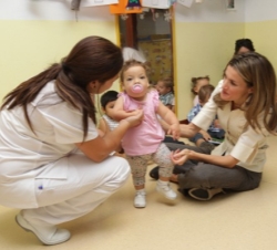 Doña Letizia saluda a una niña del centro durante la visita