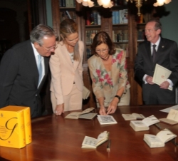 Doña Elena, junto al director de la RAE y el presidente de Mapfre, observan algunas ediciones anteriores de la Gramática
