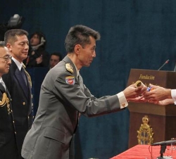 Su Alteza Real el Príncipe de Asturias entrega el diploma al Coronel, Shinji Iwakuma, en presencia de los cuatro miembros del Equipo de Respuesta de D