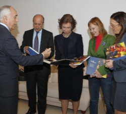 Su Majestad la Reina durante la entrega delálbum de fotos de viajes de cooperación, por parte de los cuatro secretarios de Estado de Cooperación